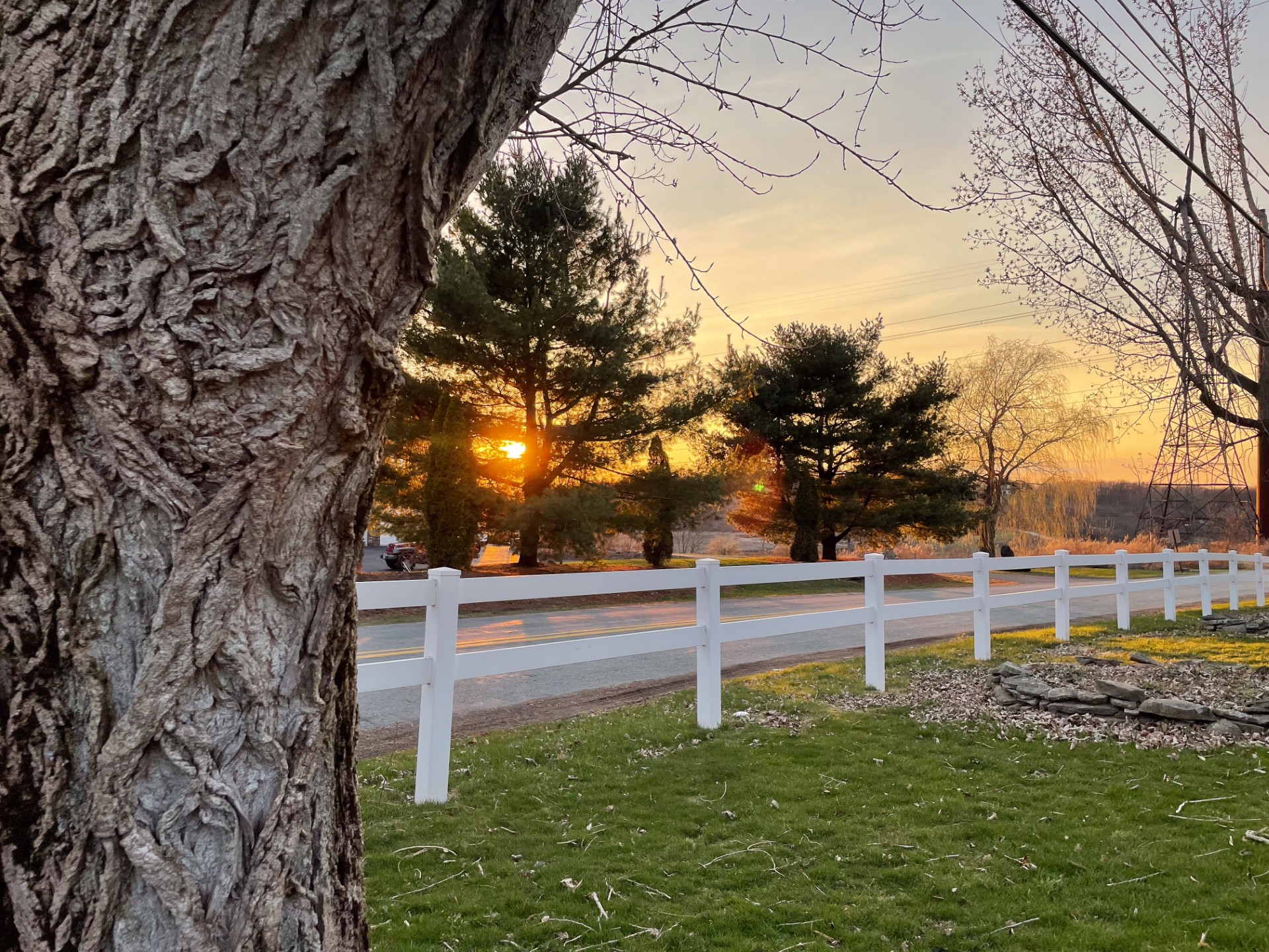 A road, a fence and a setting sun